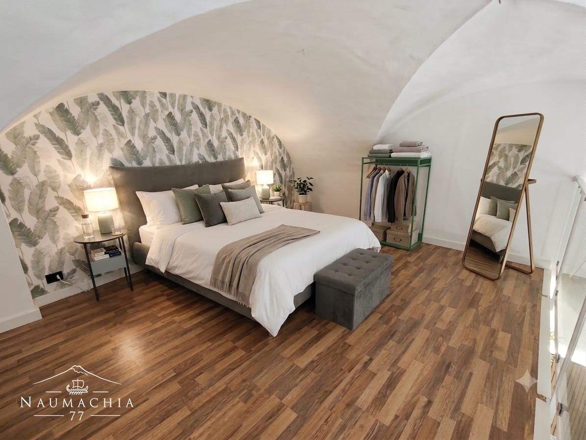 Camera da letto con soffitto a volta e parete decorata a foglie